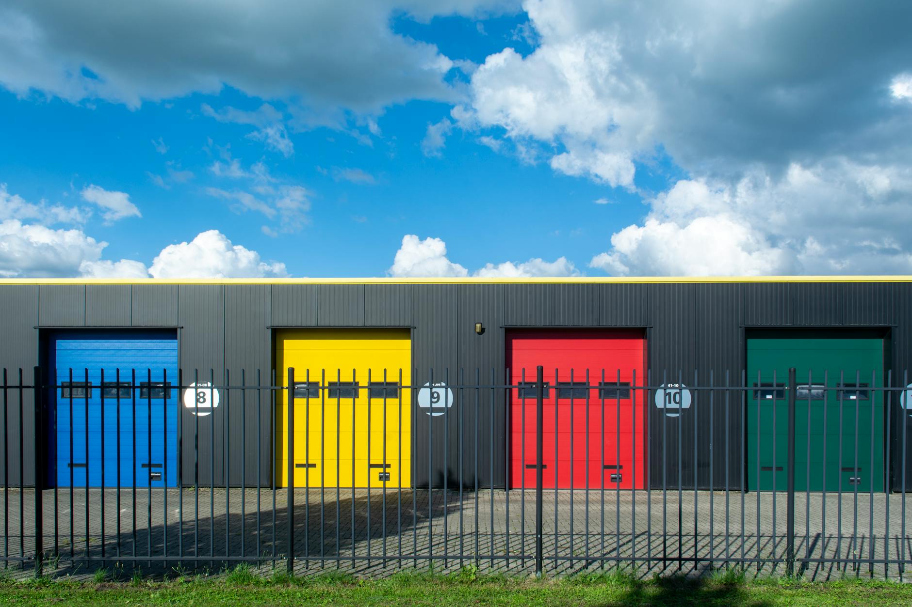 Kolorowe stalowe bramy garażowe na tle jasnego, błękitnego nieba