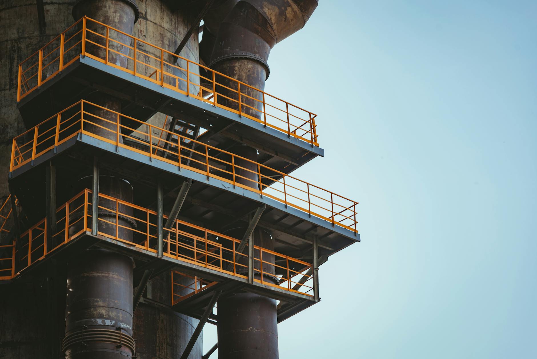 Stalowe balkony i rury instalacyjne na tle czystego, jasnego nieba