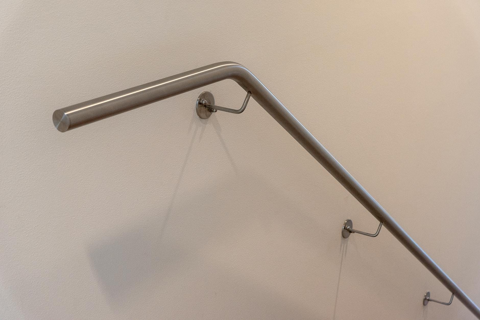 Balustrada ze stali nierdzewnej na beżowej ścianie w nowoczesnym wnętrzu