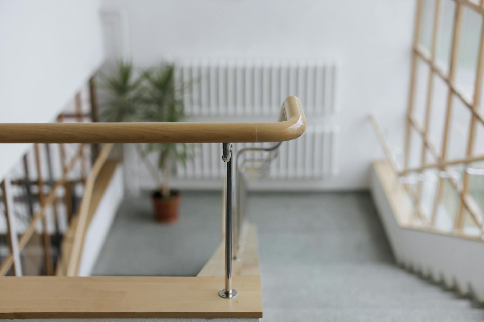 Jak zaplanować balustrady w domu seniora lub dla osób z niepełnosprawnościami ruchowymi Drewniana balustrada przy schodach w nowoczesnym wnętrzu domu