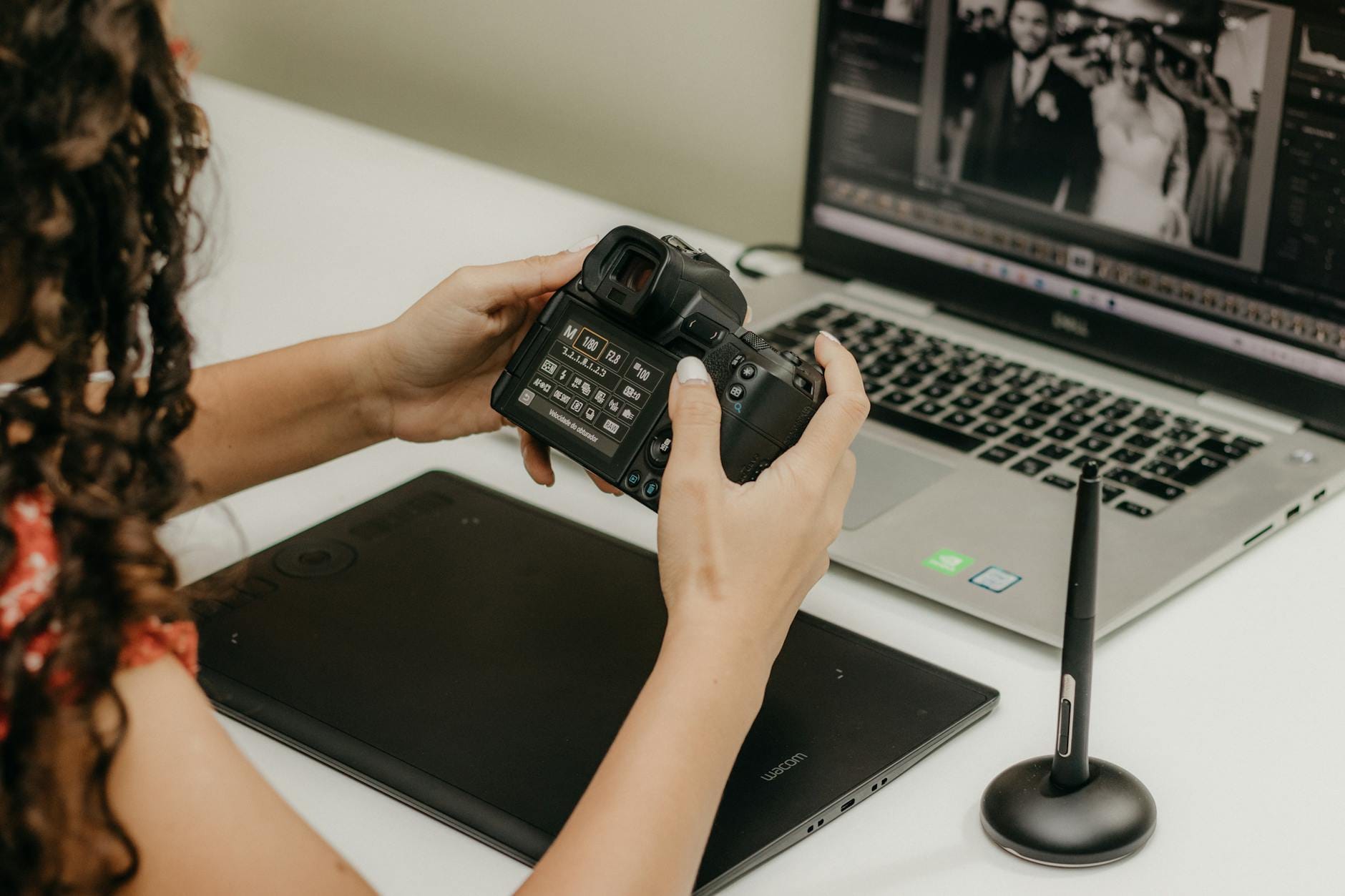 Fotografka edytuje zdjęcia w Lightroomie na laptopie z tabletem grafikiem